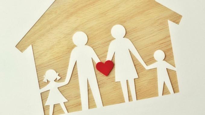 En papirfamilie på et træhus, der holder et hjerte til at repræsentere kærlighed, støtte og ADHD-hjælp