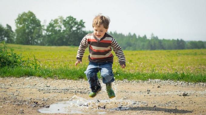 Dreng med ADHD hopper i en mudderpytter