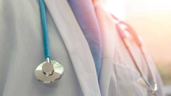 Læge eller læge i hvid kjole uniform med stetoskop på hospital eller klinik