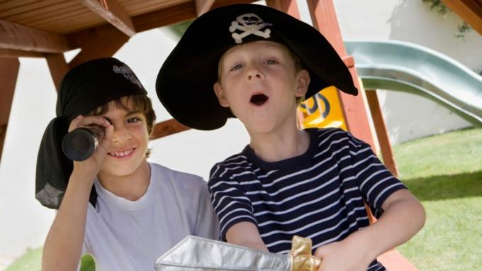To drenge med ADHD spiller pirater på legepladsen i kostumer
